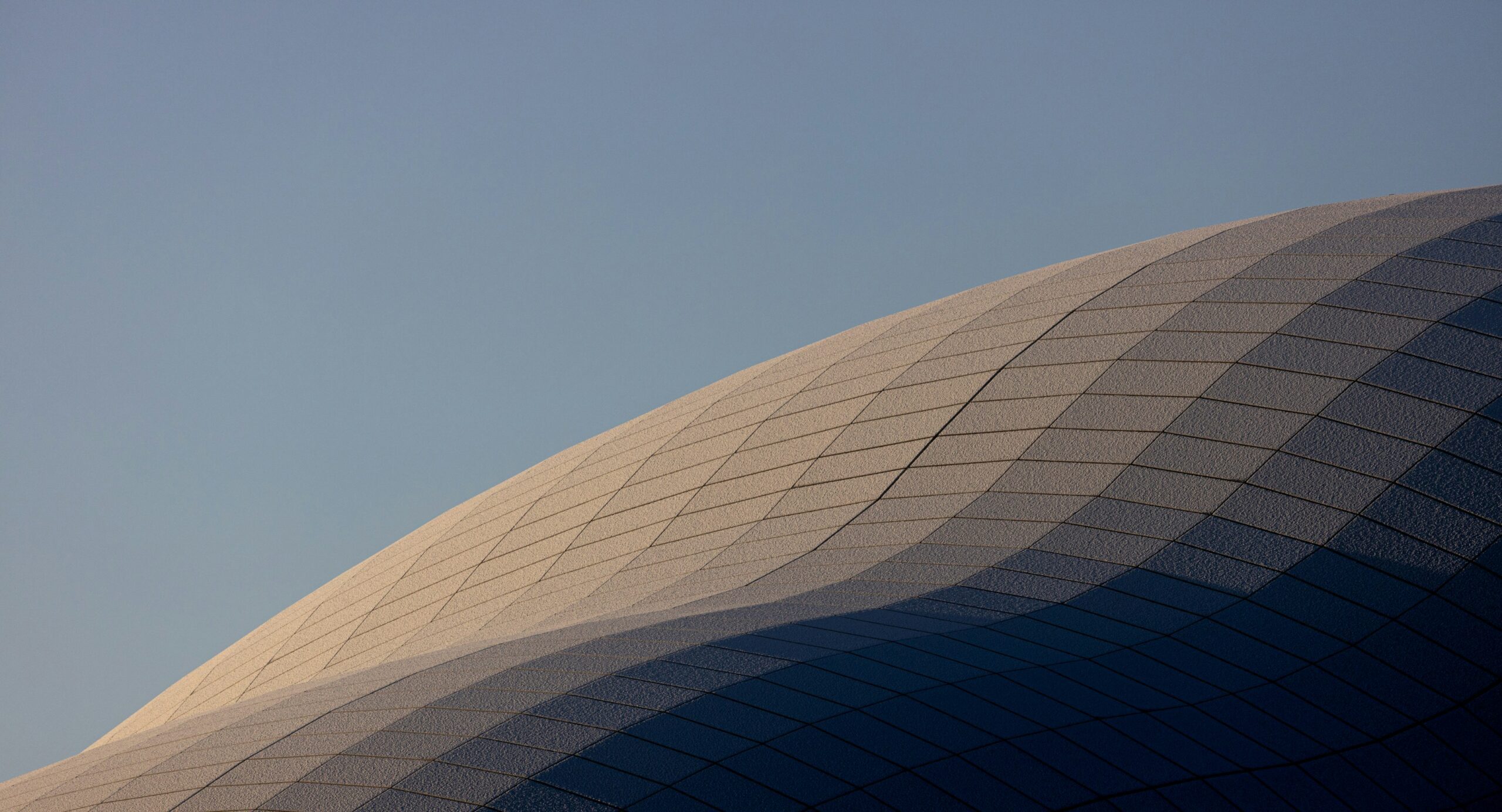 a large building with a plane flying in the sky